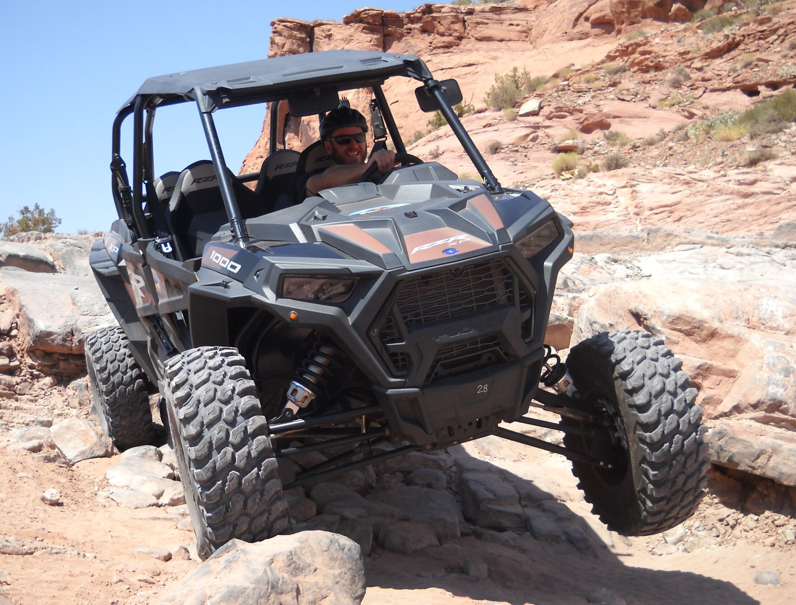 Lifting a tire on one of Moab's most iconic trails Poison Spider Mesa UTV side by side tour